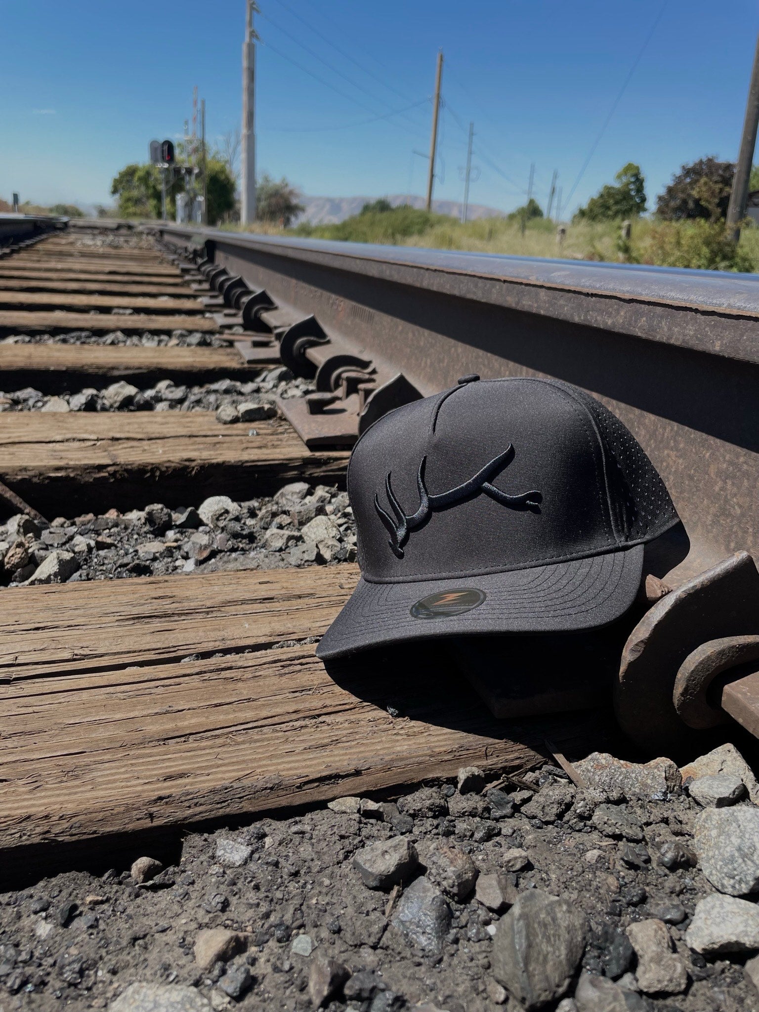 Custom Hat - Embroidered elk antler on hat on train track.